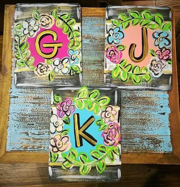 three wooden blocks decorated with flowers and the letters g, j, and k on them