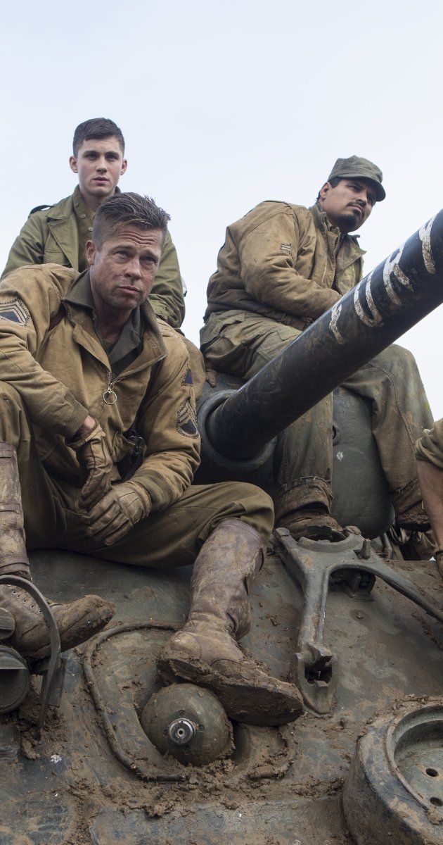 a group of men sitting on top of a tank