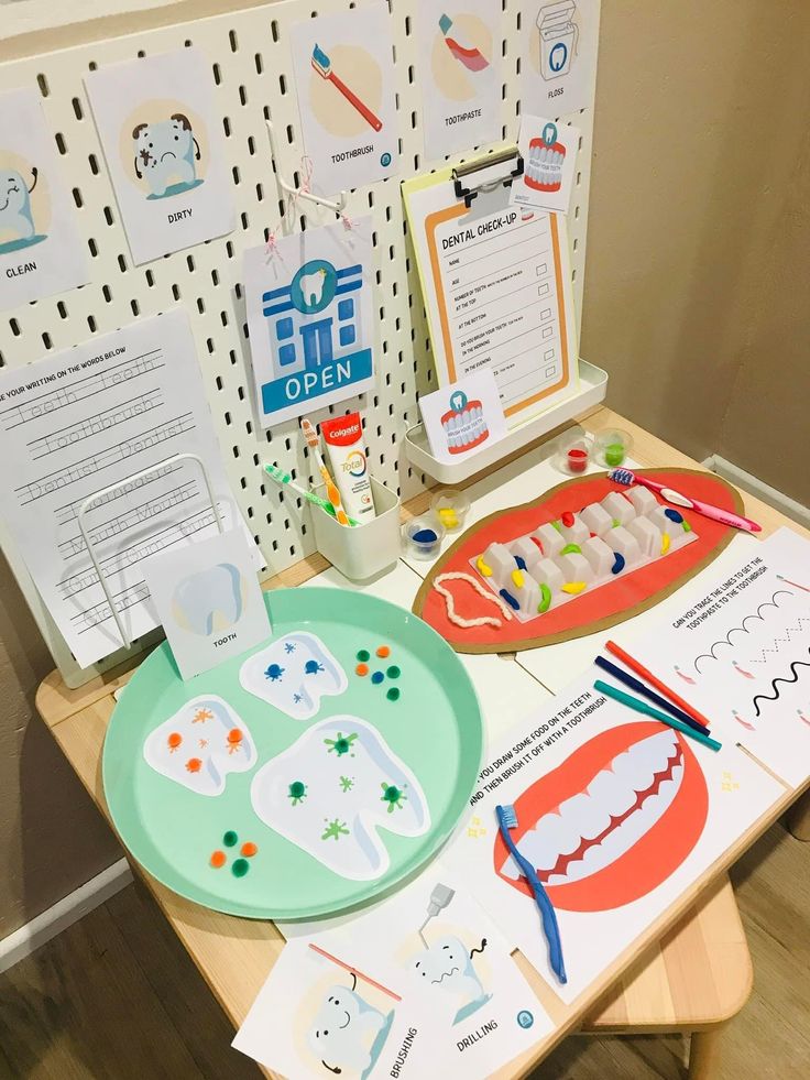 the table is set up with paper cutouts and other crafting supplies for children to make