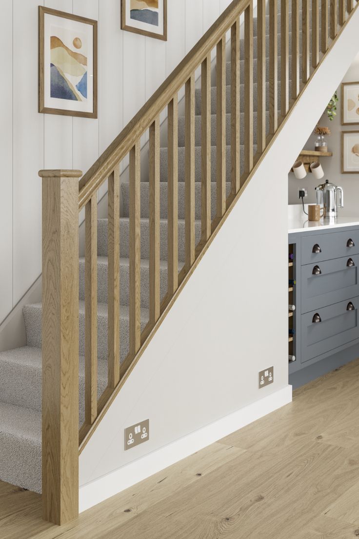 the stairs in this house are made of wood and have grey painted drawers under them