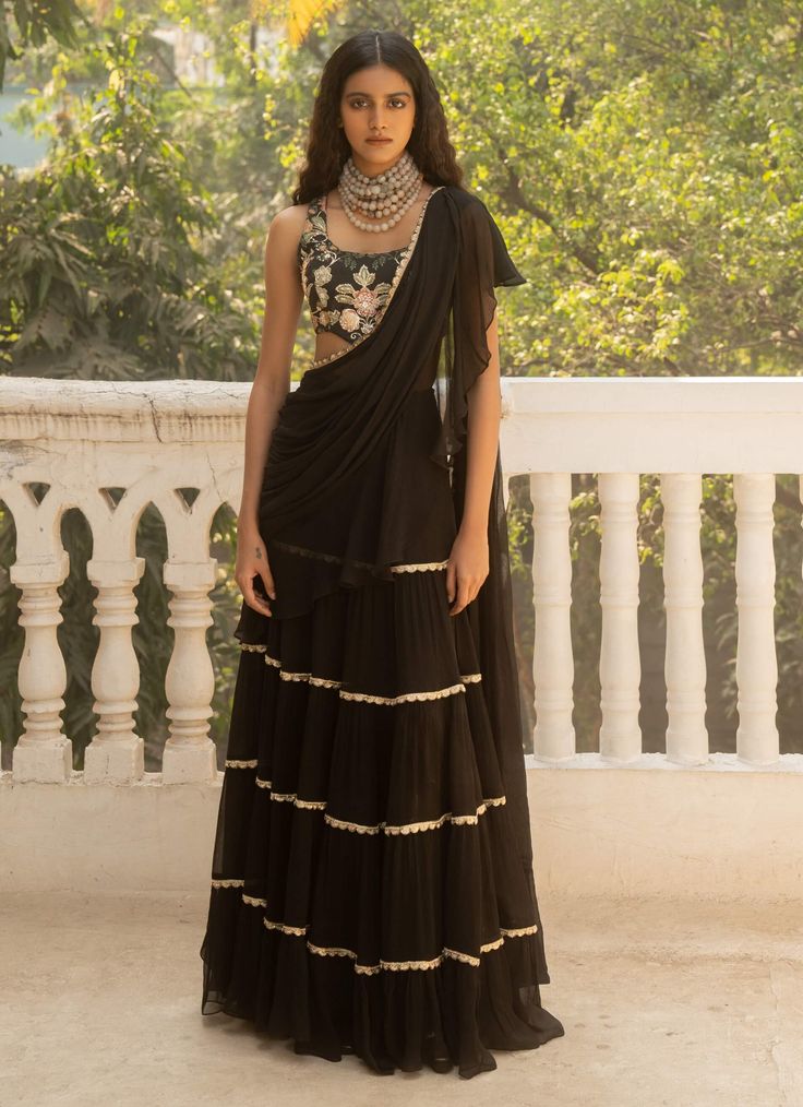 Elevate your style with this black pre-stitched chiffon sari, crafted from pure chiffon and adorned with elegant lace detailing. Paired with a print-embroidered corset blouse, this ensemble offers a chic and sophisticated look. Designer Black Draped Saree, Black Georgette Draped Saree, Black Draped Georgette Saree, Traditional Black Draped Saree, Silk Chiffon Party Pre-draped Saree, Black Draped Saree With Sheer Dupatta, Festive Pre-draped Saree With Lace Work, Elegant Lace Work Choli With Traditional Drape, Elegant Choli With Lace Work In Traditional Drape