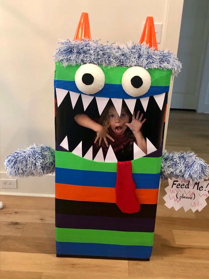 a child in a monster costume with his mouth open