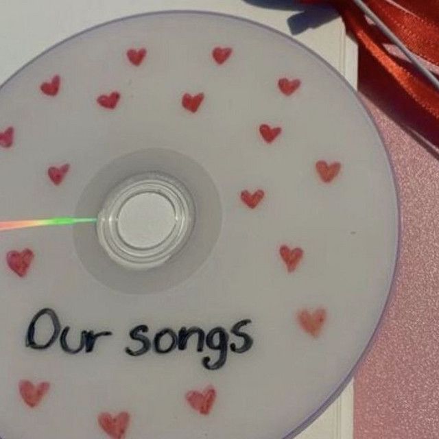 a cd with hearts on it and the words our songs written in cursive writing