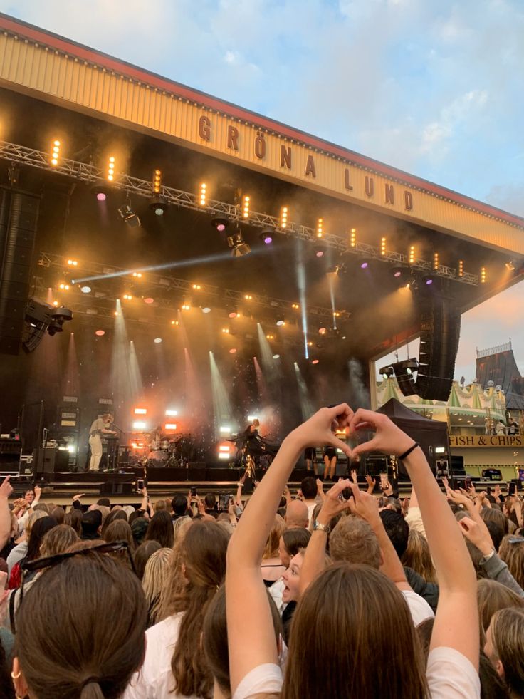 a group of people standing on top of a stage holding their hands in the air