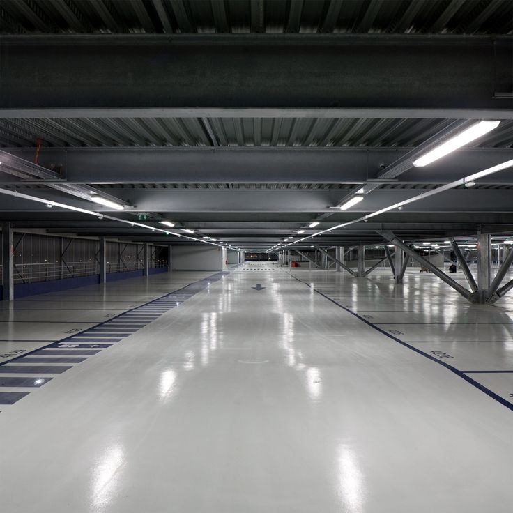 an empty parking garage with white floors and blue lines painted on the floor in front of it