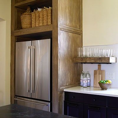 a stainless steel refrigerator freezer sitting inside of a kitchen next to a counter top