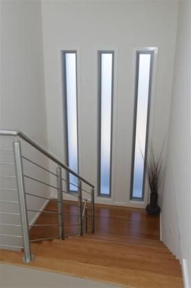 an empty staircase leading to two doors and a plant in a vase on the floor