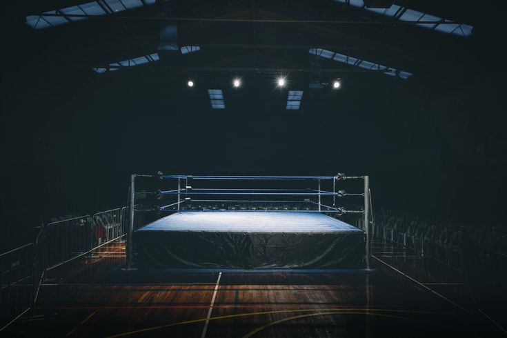 an empty boxing ring in the middle of a dark room