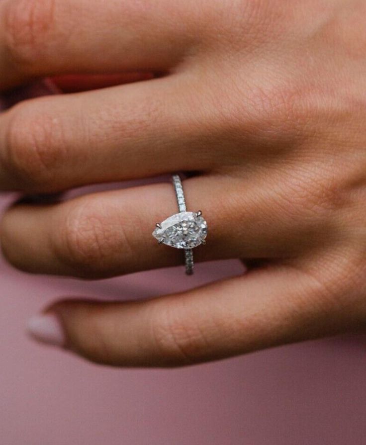 a woman's hand with a diamond ring on it