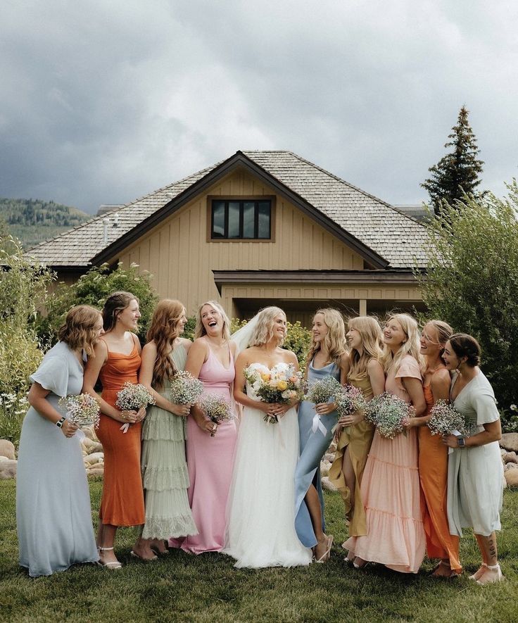 a group of women standing next to each other in front of a house