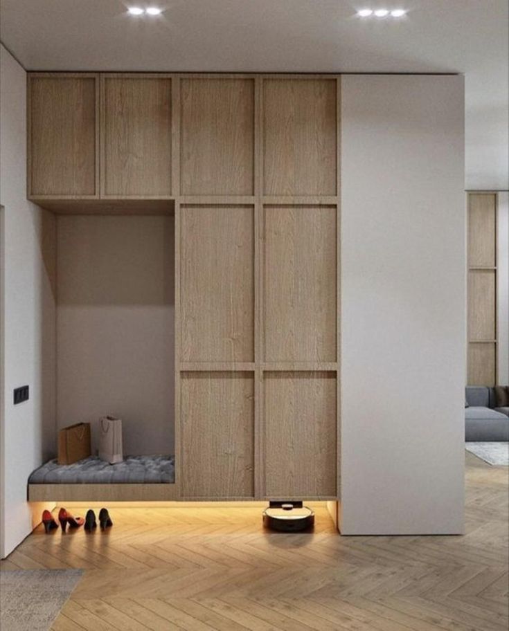 an empty room with wooden shelves and shoes on the floor in front of it,