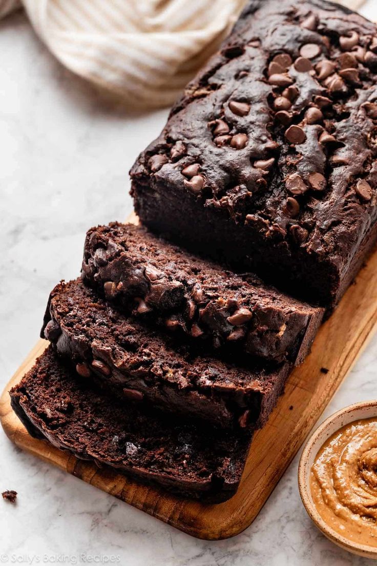 a loaf of chocolate bread sitting on top of a wooden cutting board