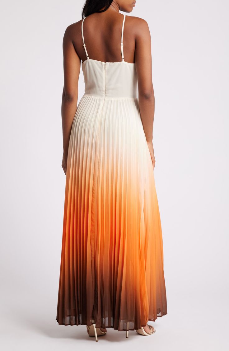 a woman wearing an orange and white ombreed dress with spaghetti straps, back view