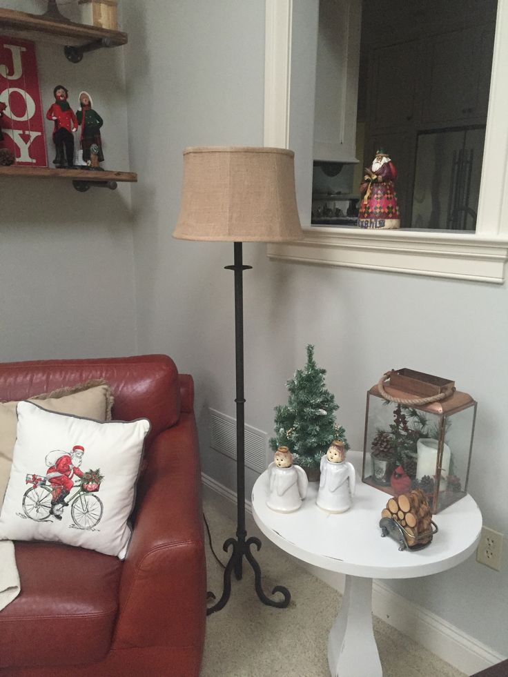 a living room with a red couch and christmas decorations on the table next to it