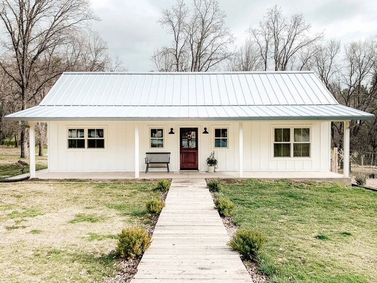 a small white house with a red door