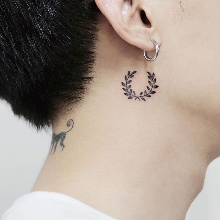 a woman with a tattoo on her neck and behind her ear is a black cat