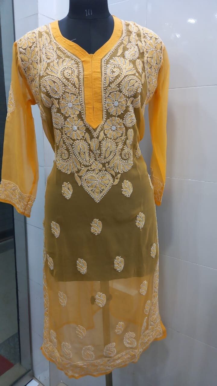 Product Details : Kurti Type : Chikankari   Type :  Embroidered Neck Type : V-neck Stitched : yes Length : 40 Inches Attached Sleeves : yes Sleeves Length : 19 Inches Color : As shown in the picture Work : chikankari/ Embroidered Pattern : Floral Print / Checkered / Paisley / Printed kurti Weight : 0.450 kg Occasion: Party Wear, Formal Wear, Festival Wear , Marriage Function Wear, Casual Wear, Regular Use. Washing Instructions : Dry Clean Or Hand Wash In Cold Water Stitching Work : Available for an additional cost. (Please contact us for Stitching Work) Disclaimer : 1. The color of actual product may vary slightly from the images provided due to photographic lighting conditions and difference in screen resolutions. 2. There may be difference in measurement as these items are handmade. Eid V-neck Kurta With Intricate Embroidery, Traditional Georgette V-neck Kurta, Traditional V-neck Georgette Kurta, Eid Georgette V-neck Kurta, Eid V-neck Georgette Kurta, Festive V-neck Self Design Kurta, Semi-stitched V-neck Salwar Kameez For Festivals, Anarkali Kurta With Intricate Embroidery And V-neck, Semi-stitched V-neck Kurta