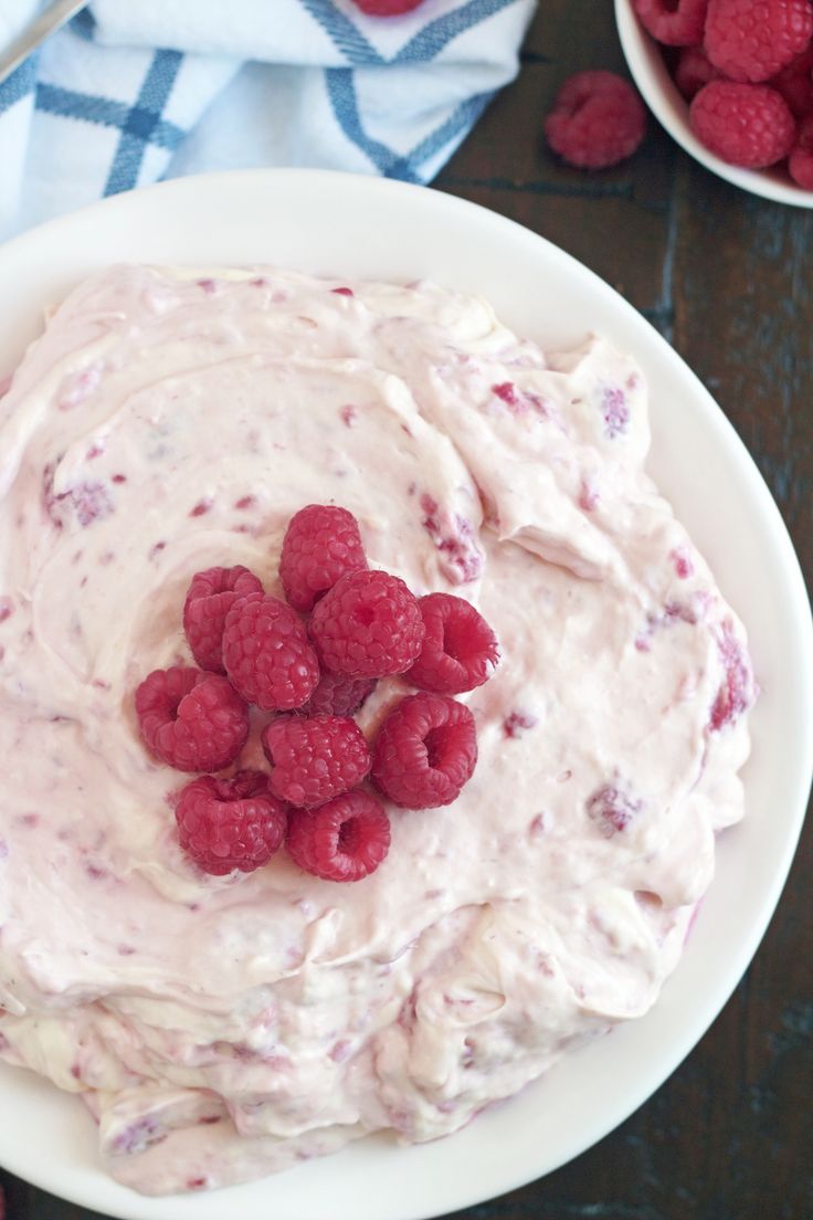 a bowl filled with raspberries on top of a table