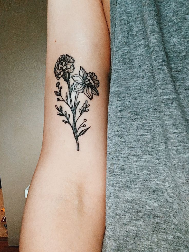 a woman's arm with a flower tattoo on the left side of her arm