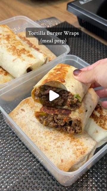 a person holding a burrito in their hand next to two containers filled with food