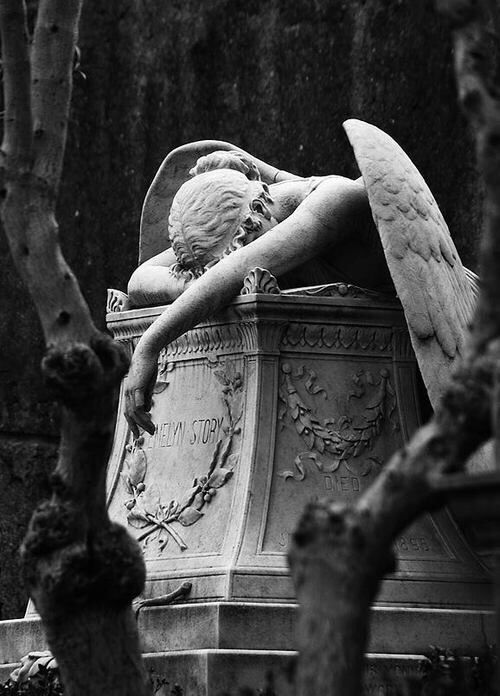 an angel statue sitting in the middle of a cemetery