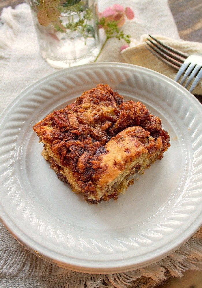 a white plate topped with two pieces of cake next to a fork and glass cup