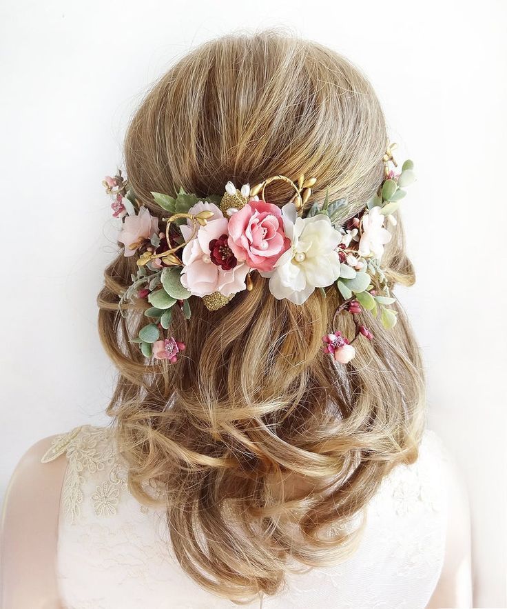 the back of a woman's head with flowers in her hair, wearing a white dress