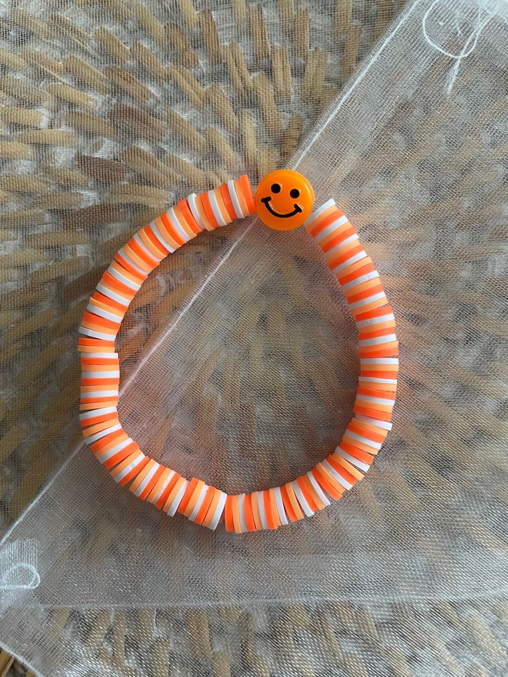 Orange, light orange, and white bracelet Casual Orange Friendship Bracelets For Beach, Handmade Orange Casual Friendship Bracelet, Casual Handmade Orange Friendship Bracelets, Casual Handmade Orange Friendship Bracelet, Casual Orange Bracelets For Beach, Casual Orange Jewelry For Friendship, Fun Orange Bracelets For Gifts, Playful Orange Beaded Bracelets With Letter Beads, Playful Orange Bracelets For Beach