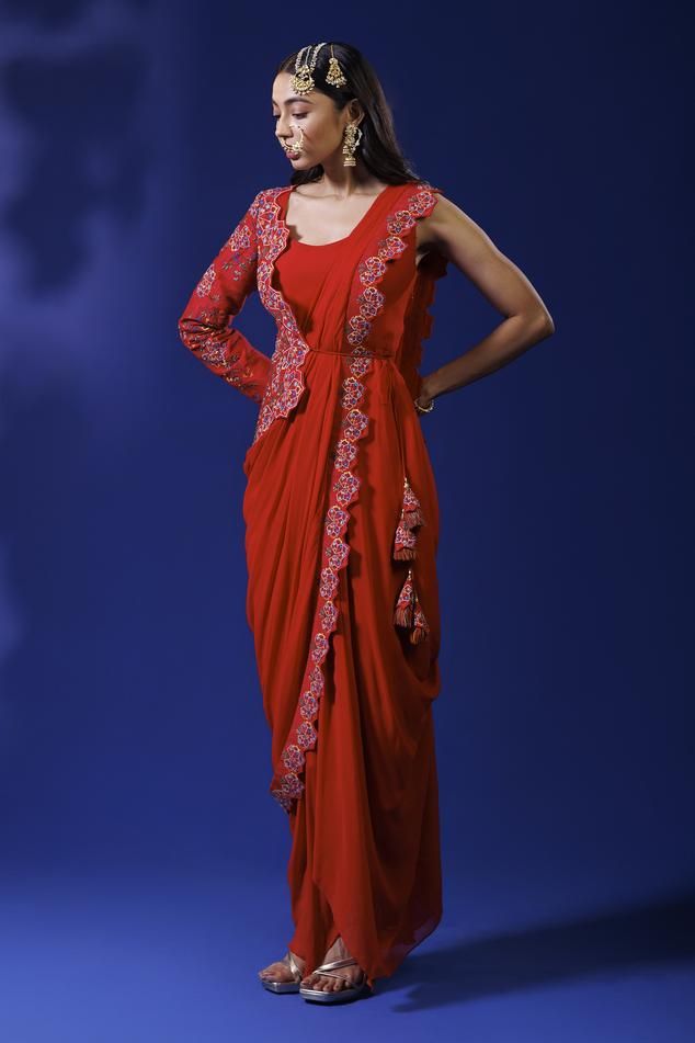 Red saree gown with thread embroidery in floral pattern and one sided full sleeve jacket. Paired with detachable crossbody dupatta.
Components: 2
Pattern: Embroidery
Type Of Work: Thread
Neckline: Round
Sleeve Type: Asymmetric
Fabric: Raw Silk, Georgette
Color: Red
Other Details: 
Asymmetric hem
Occasion: Sangeet - Aza Fashions Festive Pre-draped Maxi Length Georgette Saree, Red Dress With Pallu And Traditional Drape, Red Anarkali Pre-draped Saree With Traditional Drape, Bollywood Style Evening Dress With Pallu, Bollywood Evening Dress With Pallu, Festive Evening Pre-draped Saree Floor-length, Festive Evening Floor-length Pre-draped Saree, Festive Evening Pre-draped Saree, Sheer Dupatta Draped Gown For Reception