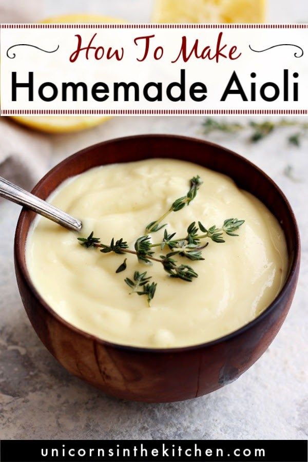 a wooden bowl filled with homemade aioli and garnished with fresh thyling