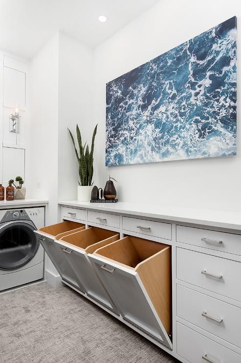 a washer and dryer in a white room with blue waves on the wall