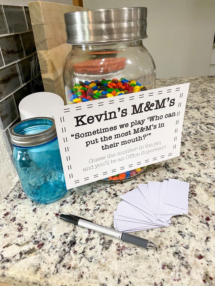 a jar filled with candy sitting on top of a counter next to a sign that says kern's m & m's