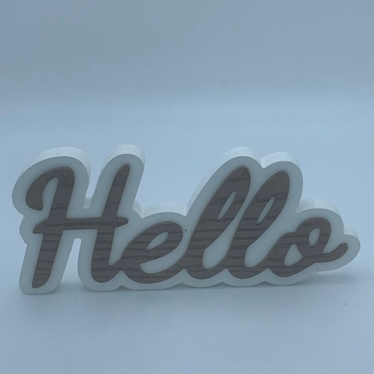 the word hello spelled in grey and white letters on a plain surface with no background