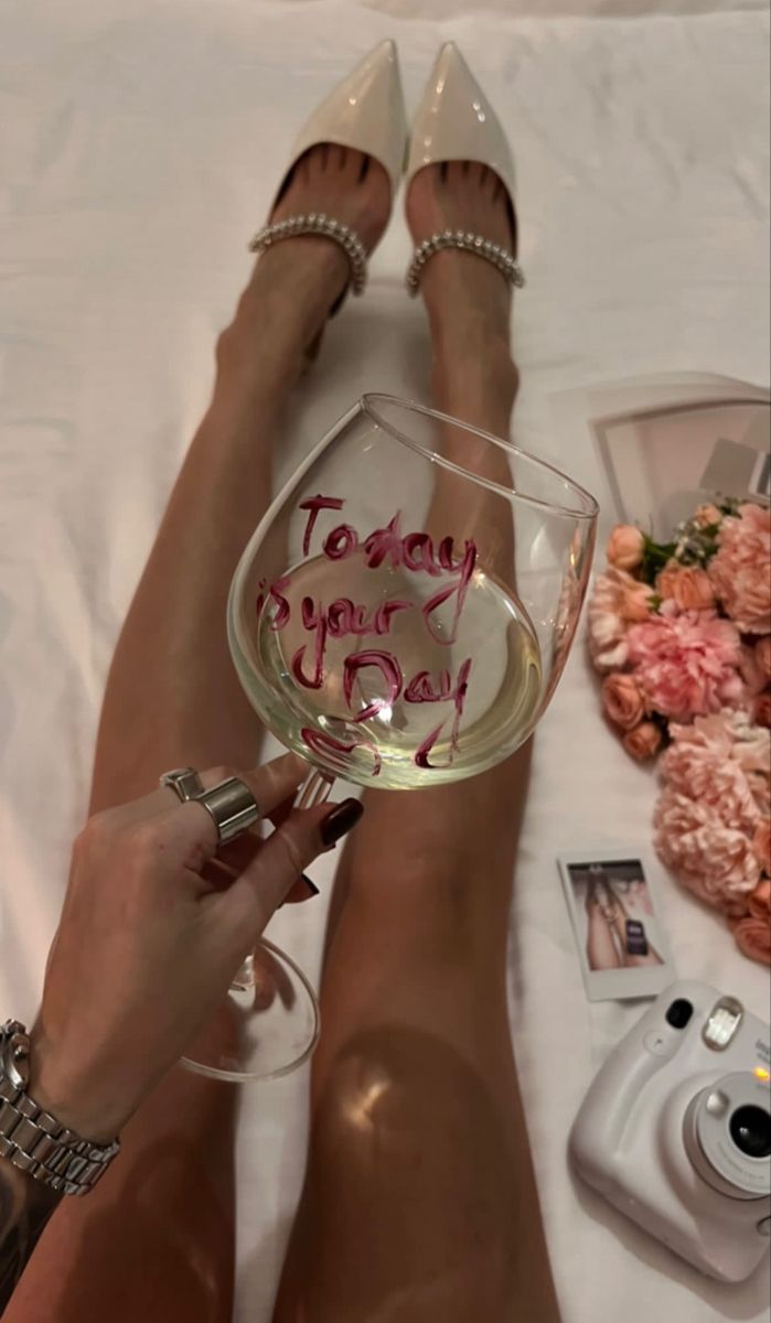 a woman holding a wine glass with the words today is your day written on it