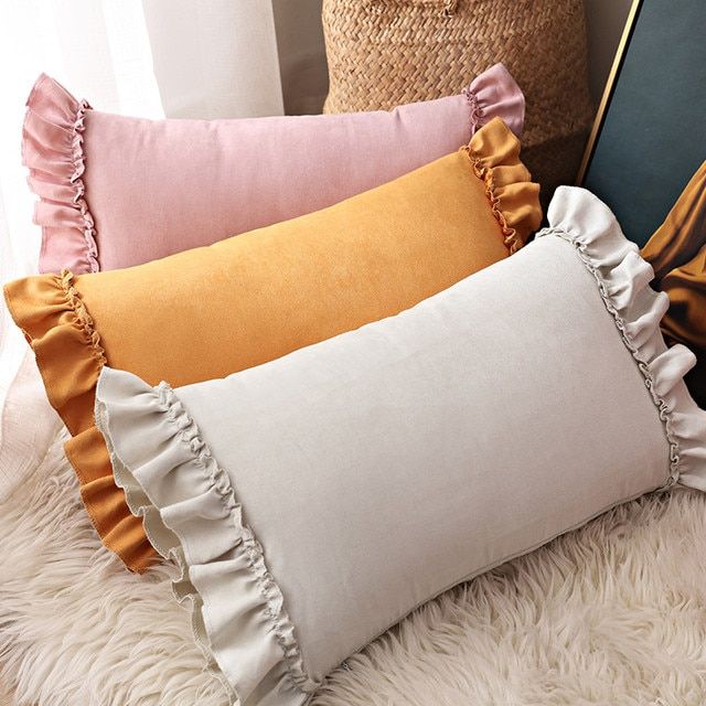 three pillows with ruffled edges on a fluffy rug