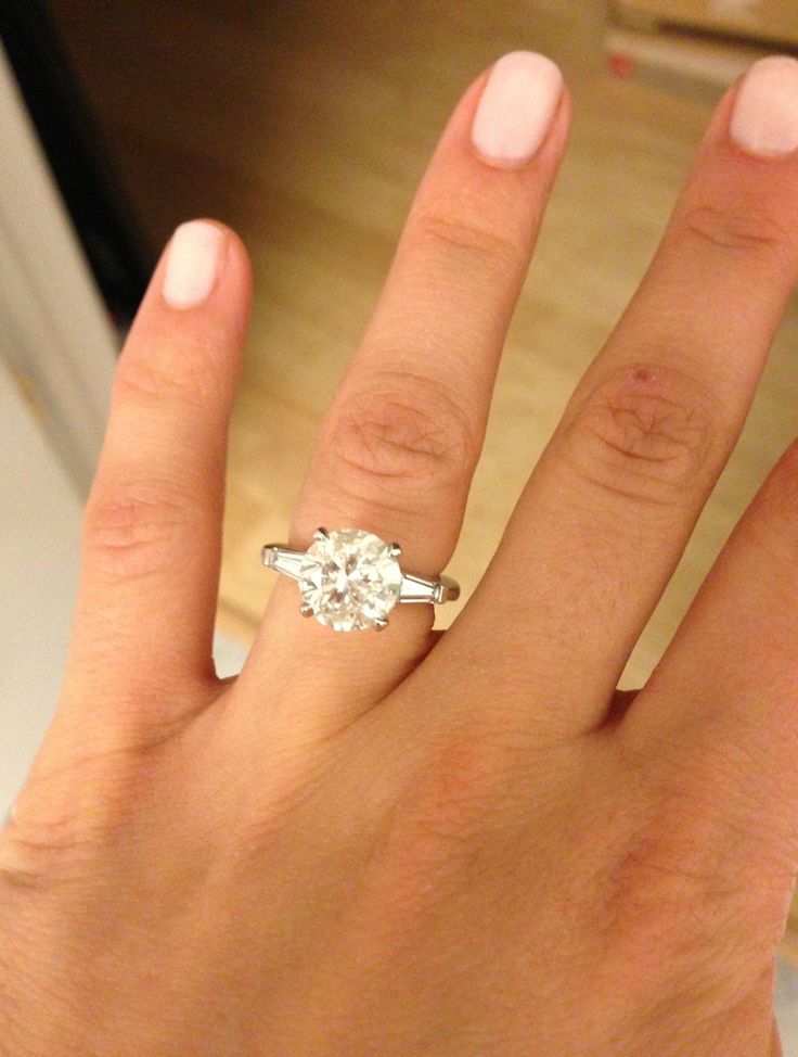 a woman's hand with a diamond ring on it