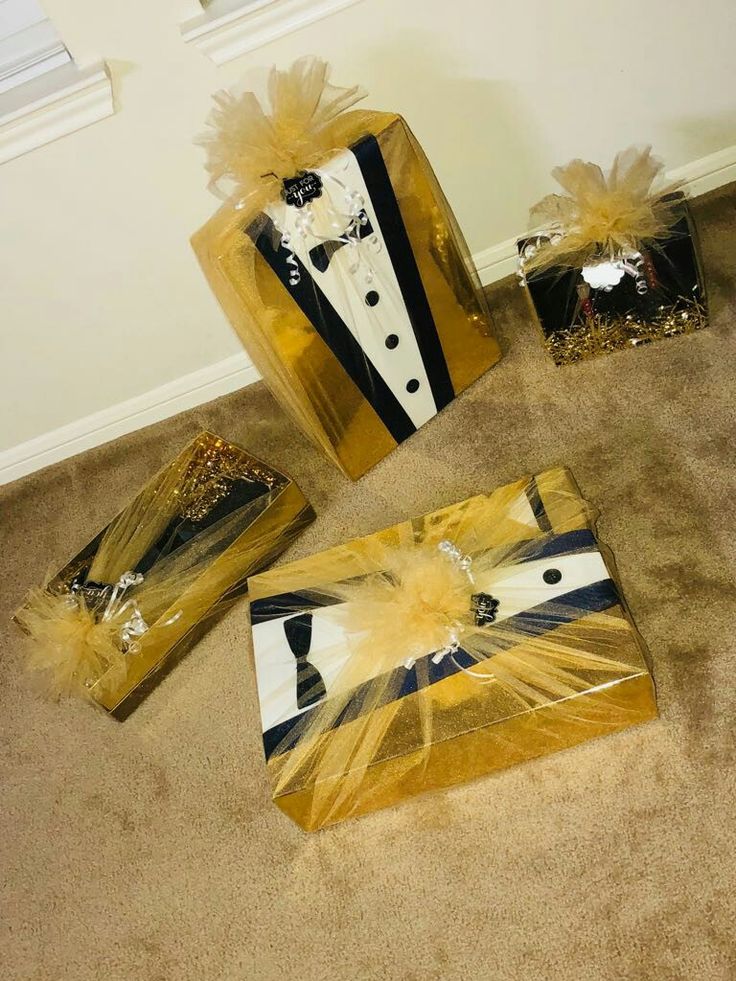 three gift bags with tuxedos and sequins on them sitting on the floor