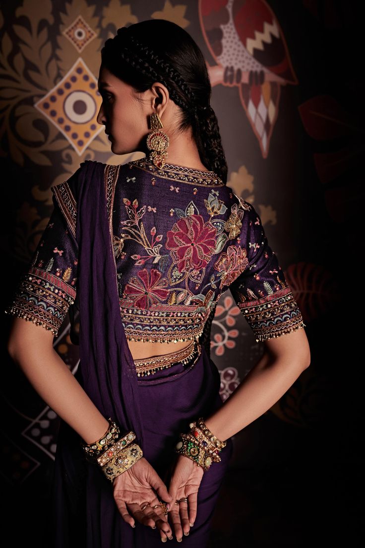 Editor's Note Chiffon Draped Saree With Raw Silk Embroidered Blouse And Belt Fabric: Blouse: Raw Silk, Saree: Chiffon Color: Purple Care: Dry Clean Only About the Designer Ridhi Mehra follows a minimalist yet effective design philosophy, working with solid colors and floral embroidery. She has brought together western influences to Indian garments, thus creating her signature contemporary Indian wear, such as her part line of embroidered crop tops which was a runway success. Purple Drapes, Ridhi Mehra, Draped Saree, Blouse Designs Indian, Saree Blouse Patterns, Drape Saree, Elegant Blouse Designs, Unique Blouse Designs, Saree Blouse Designs Latest