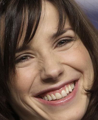 a close up of a smiling woman with brown hair