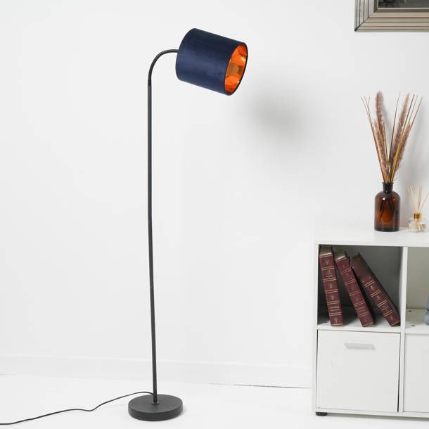 a blue floor lamp with an orange light on it in front of a white wall