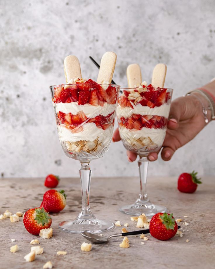 two glasses filled with ice cream and strawberries