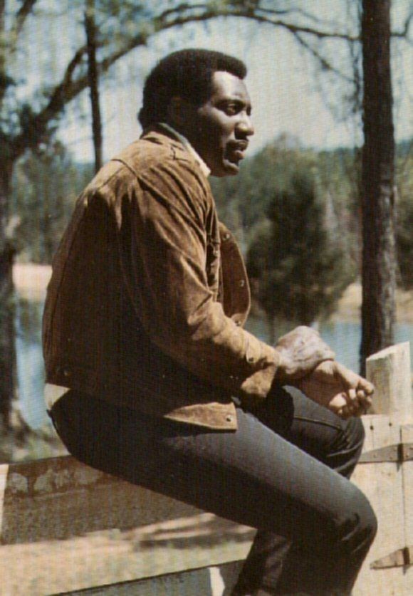 a man sitting on top of a wooden bench