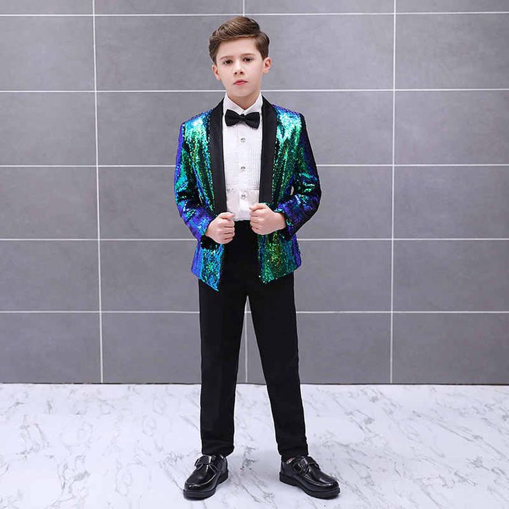 a young boy dressed in a blue and green sequin suit with black bow tie