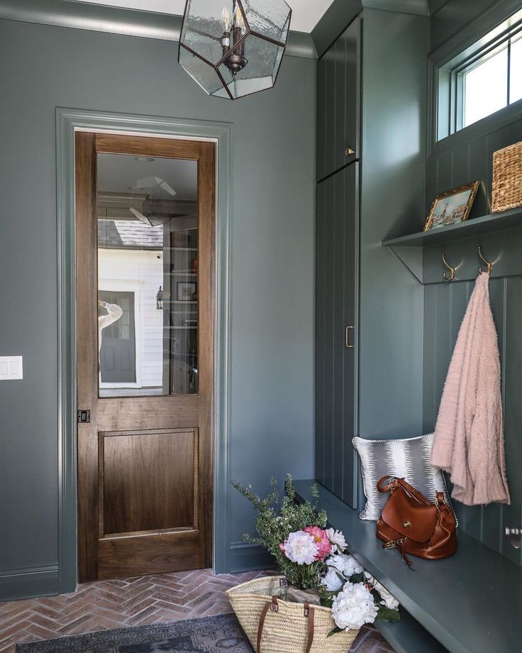 an entryway with gray walls and wooden door