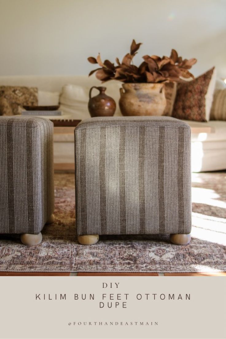 two couches sitting on top of a rug in front of a vase with flowers