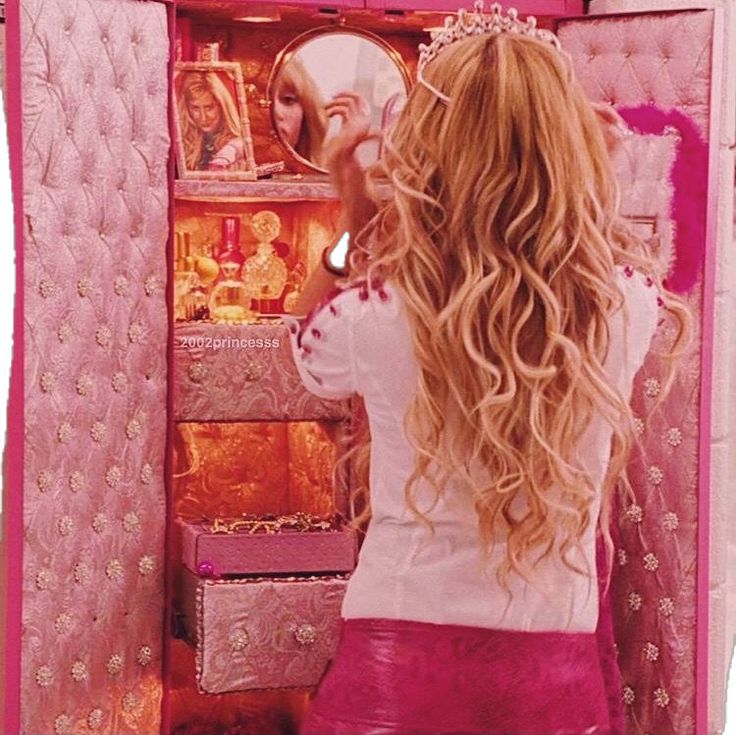 a woman is looking at her reflection in the mirror while she brushes her long hair