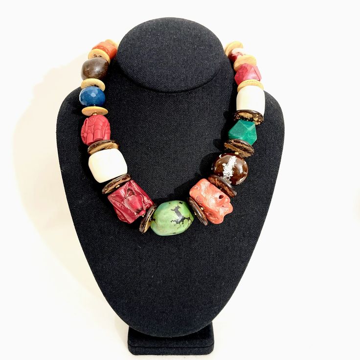 A statement choker necklace with a mix of natural stones; red, orange, and white Coral, genuine Turquoise, Coconut, Buckeye seeds, Cinnabar elephant, and Agate.  A multicolor display of natural stones makes a natural statement with a large Turquoise centerpiece. Artisan Multicolor Necklace With Large Beads, Artisan Multicolor Necklaces With Large Beads, Unique Multicolor Wooden Beads Necklaces, Unique Multicolor Wooden Beads, Multicolor Wooden Beads, Bohemian Multicolor Gemstone Jewelry, Bohemian Multicolor Gemstone Beaded Necklace, Adjustable Natural Stone Beaded Necklaces, Unique Multicolor Wooden Bead Jewelry