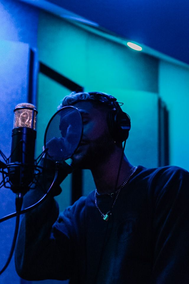 a man with headphones on singing into a microphone