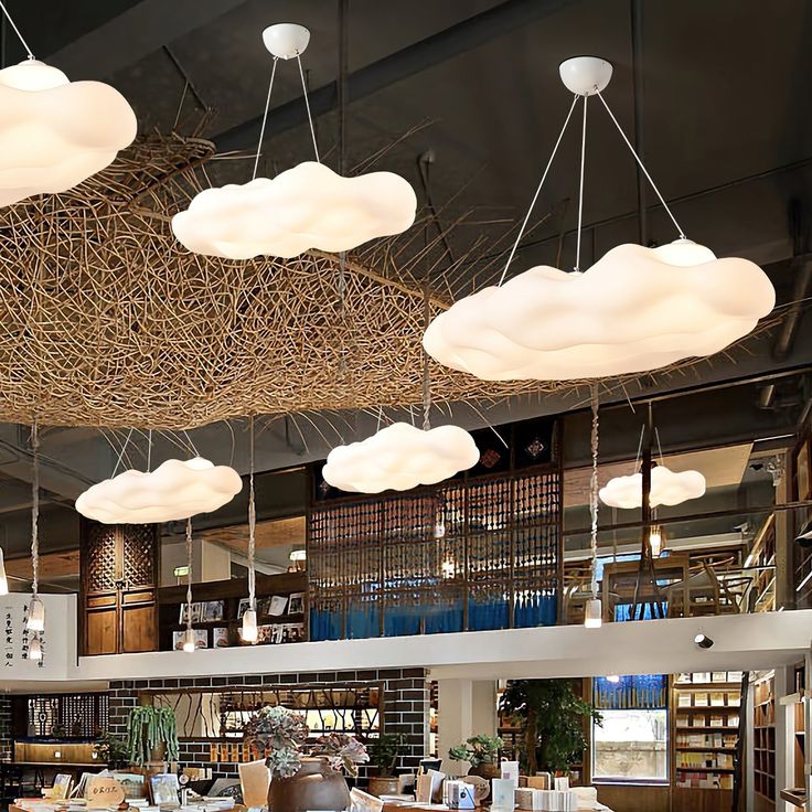 a restaurant with wooden tables and white clouds hanging from the ceiling