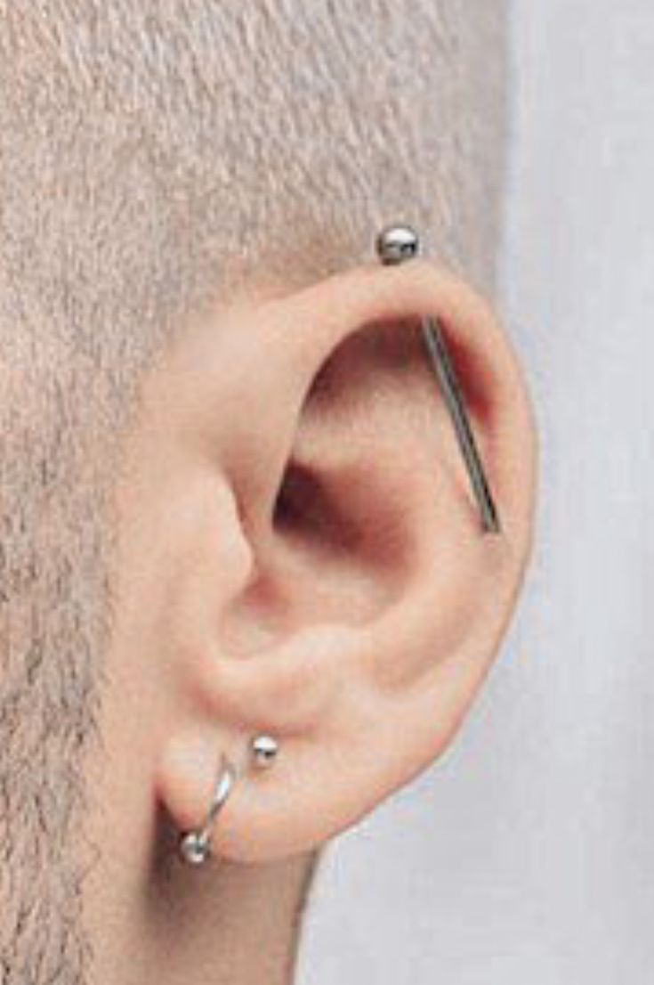 a man with piercings on his ears is looking at the side of his head